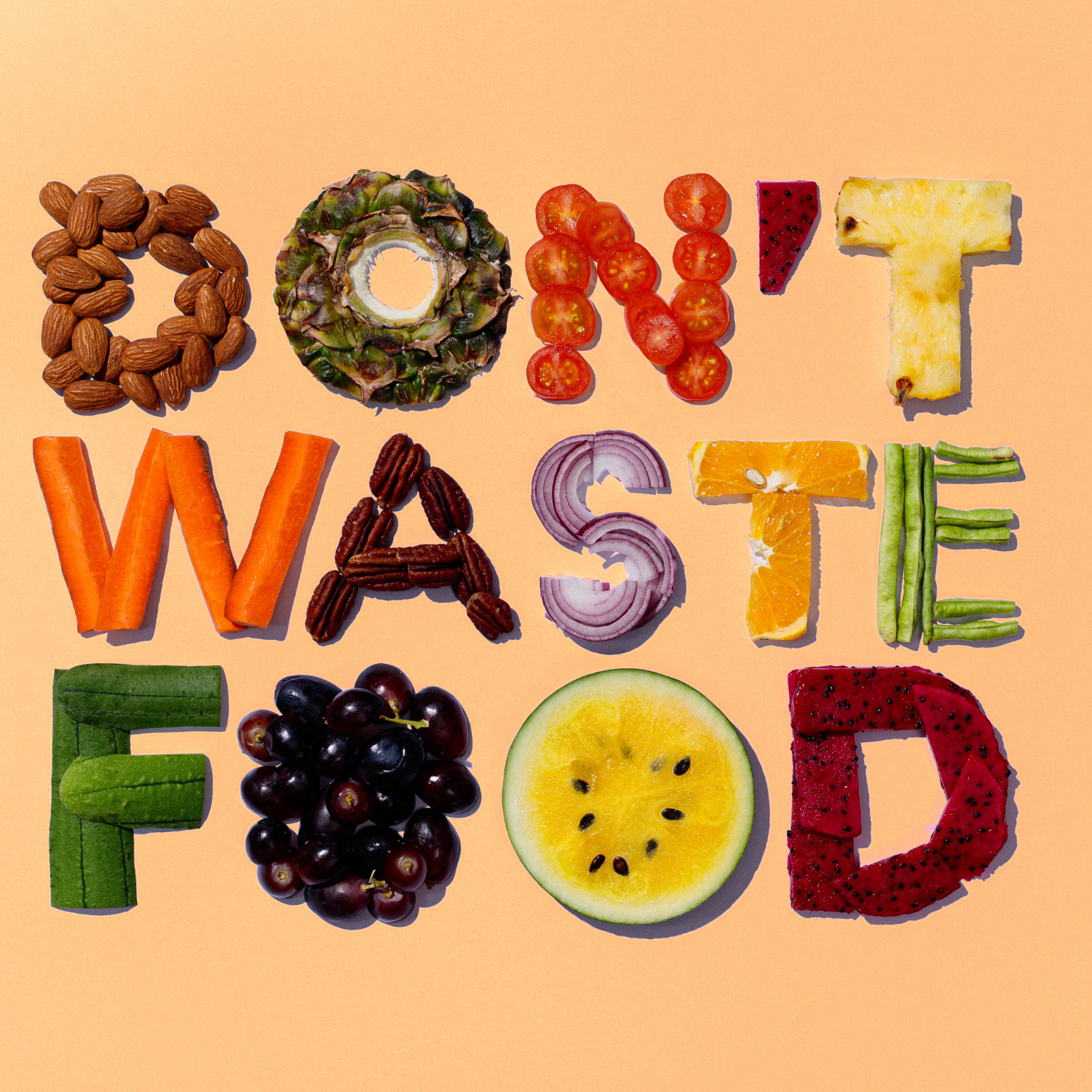 Schriftzug „Don’t waste food“ aus Lebensmitteln gelegt – Botschaft gegen Lebensmittelverschwendung.