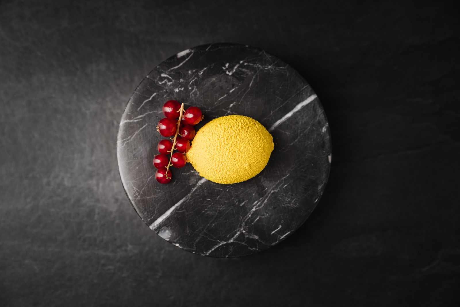 Zitronenförmiges Lemon-Curd-Dessert mit roten Johannisbeeren