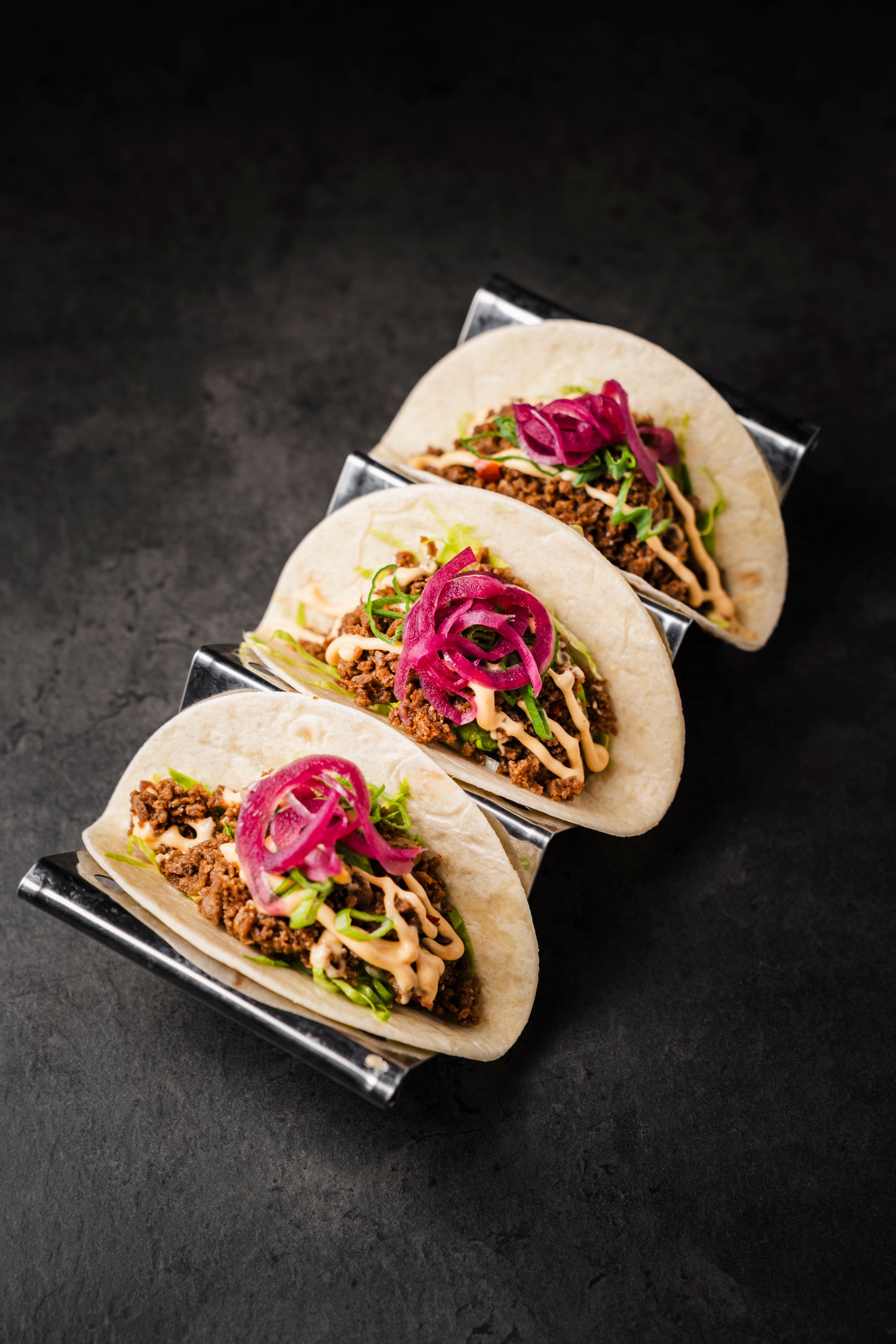 Drei Mini Tacos mit Hackfüllung, Salat und eingelegten Zwiebeln