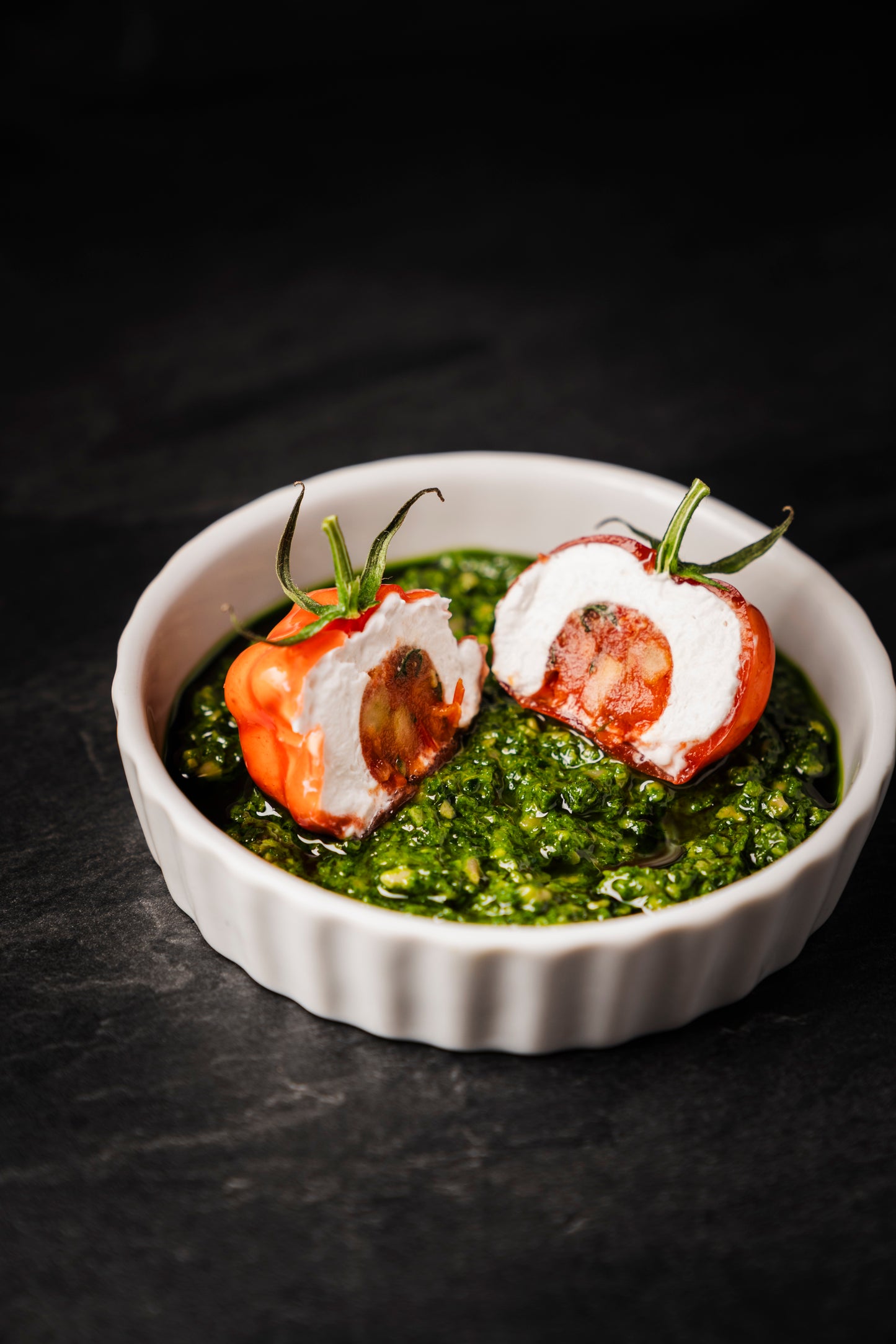 Tomate Mozzarella mit Tomatenrelish auf Basilikumpesto in einer Portionsform